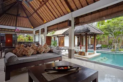a living room with a couch and a table and a pool at The Maya Seminyak Villas in Seminyak