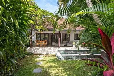 a backyard with a pool and a house at Twist and Shout Villa in Seminyak