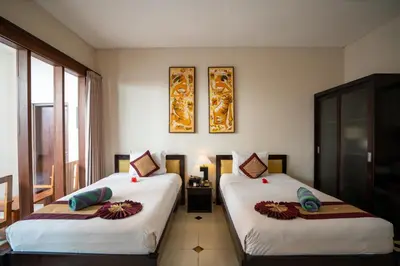 two beds in a hotel room with at Baleka Resort & Spa in Legian