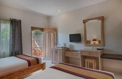 a bedroom with two beds and a mirror and a desk at Baleka Resort & Spa in Legian
