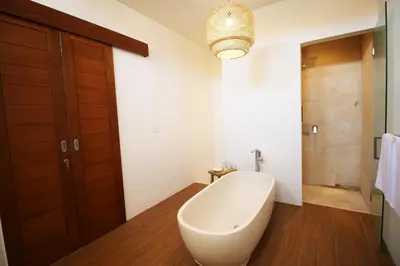 a bathroom with a large white tub in a room at Villa Aditi, Sitara Villa Group in Seminyak