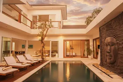 a pool in a house with chairs and a fireplace at Villa Aditi, Sitara Villa Group in Seminyak