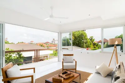 a living room with white walls and large windows at Villa Aditi, Sitara Villa Group in Seminyak