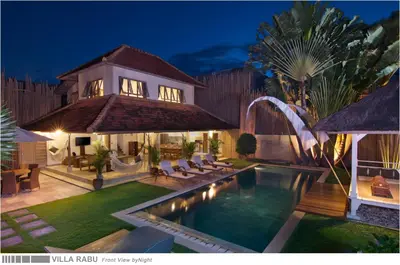 a villa with a swimming pool at night at 3BR Villa Rabu - Minggu Villas Seminyak in Seminyak