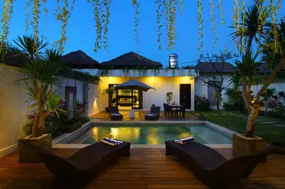 a backyard with a swimming pool and a house at Villa Calypso by Optimum Bali Villas in Seminyak