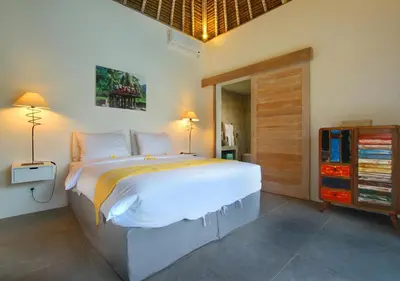 a bedroom with a large bed and a wooden door at Villa Thiara by Optimum Bali Villas in Seminyak