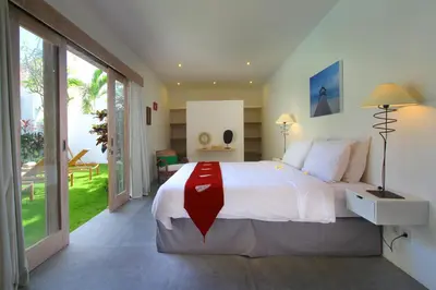 a bedroom with a large bed and a large window at Villa Thiara by Optimum Bali Villas in Seminyak