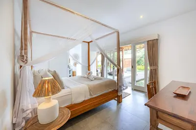 a bedroom with a canopy bed and a table at Renovated Villa Aksara Oberoi, 700m to Beach in Seminyak