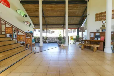 a lobby with a staircase and a table and benches at The Flora Kuta Bali in Kuta