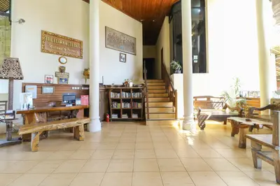a store with wooden benches and stairs in a room at The Flora Kuta Bali in Kuta