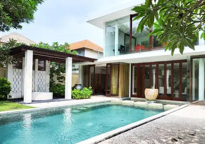 a house with a swimming pool in front of a house at The Wangsa Benoa in Nusa Dua