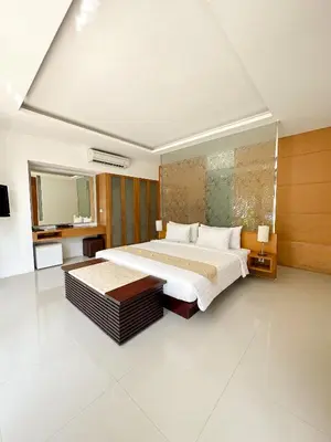 a large bedroom with a large bed and a mirror at The Wangsa Benoa in Nusa Dua