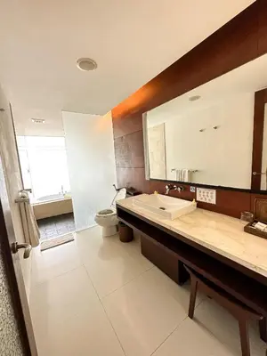 a bathroom with a sink and a toilet and a mirror at The Wangsa Benoa in Nusa Dua