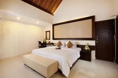 a bedroom with a large bed and a large screen at Putu Bali Villa & Spa in Seminyak