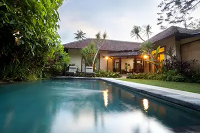 a swimming pool in front of a house at Villa Coco Bali in Seminyak