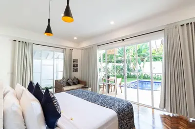 a bedroom with a bed and a large window at Villa Coco Bali in Seminyak