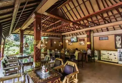 a restaurant with tables and chairs in a room at Dewa Bharata Bungalows Legian in Legian