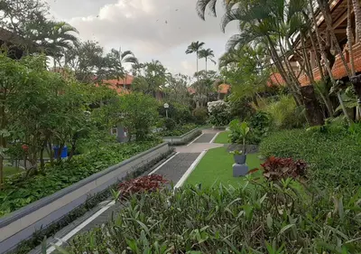 a garden with trees and plants in a building at Dewa Bharata Bungalows Legian in Legian
