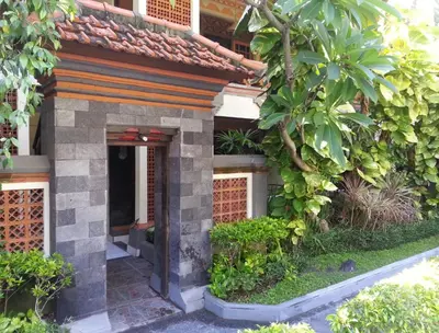 an entrance to a house with a garden at Dewa Bharata Bungalows Legian in Legian