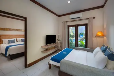 a bedroom with a bed and a tv and a couch at Rama Residence Seminyak in Seminyak
