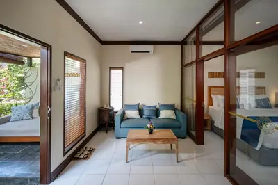 a living room with a blue couch and a table at Rama Residence Seminyak in Seminyak