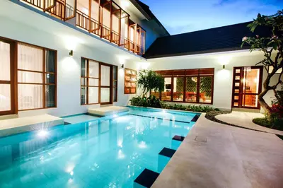 a swimming pool in the middle of a house at Pudak Sari Unizou Hostel in Kuta