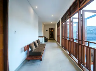 a living room with a couch and a balcony at Pudak Sari Unizou Hostel in Kuta
