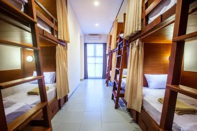 a room with several bunk beds in a hostel at Pudak Sari Unizou Hostel in Kuta