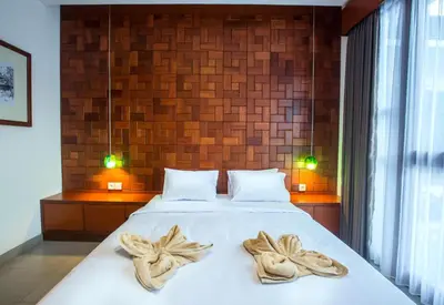 a bedroom with a bed with towels on it at Pudak Sari Unizou Hostel in Kuta