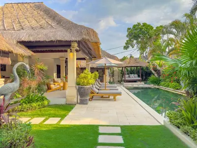 a villa with a swimming pool and a resort at Villa Bugis Seminyak in Seminyak