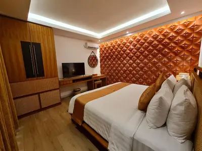 a hotel room with a bed and a flat screen tv at Lasanti Villas Seminyak in Seminyak