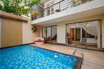 a house with a swimming pool in front of it at Lasanti Villas Seminyak in Seminyak