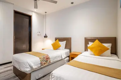 two beds in a hotel room with yellow pillows at Villa Onyx in Seminyak