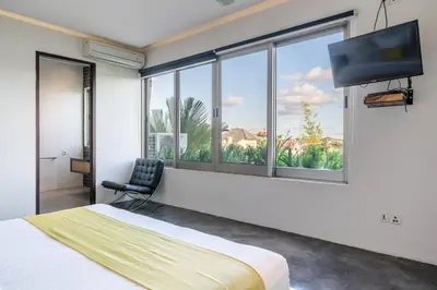 a bedroom with a bed and a flat screen tv at Villa Onyx in Seminyak