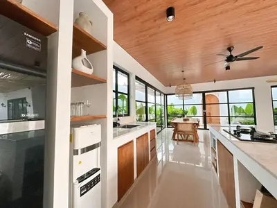 a kitchen with white counters and a ceiling fan at Amerta Villa Seminyak in Seminyak