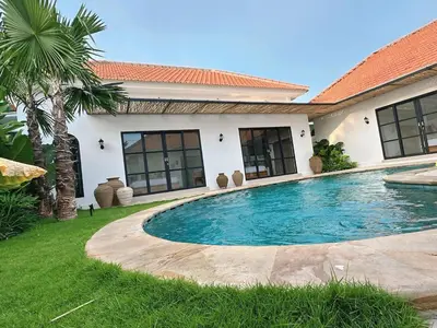 a swimming pool in front of a house at Amerta Villa Seminyak in Seminyak