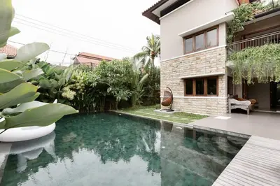 a swimming pool in front of a house at Dasa Villa in Seminyak