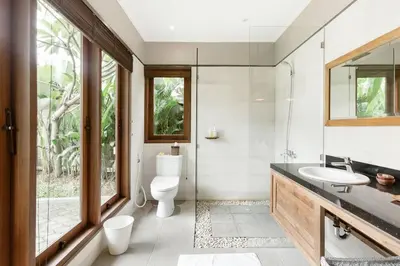 a bathroom with a sink and a toilet and a window at Dasa Villa in Seminyak
