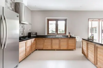 a kitchen with wooden cabinets and a stainless steel refrigerator at Dasa Villa in Seminyak