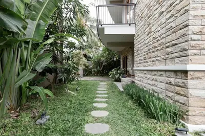 a garden with a walkway next to a brick building at Dasa Villa in Seminyak