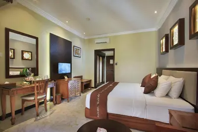 a bedroom with a bed and a desk and a computer at Pelangi Bali Hotel & Spa in Seminyak