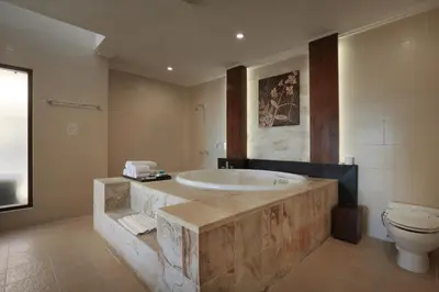 a large bathroom with a tub and a toilet at Pelangi Bali Hotel & Spa in Seminyak