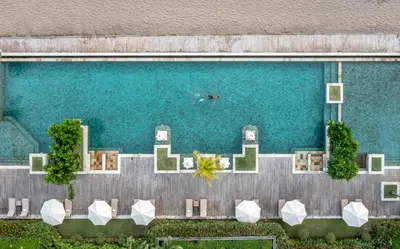 an overhead view of a pool with chairs and water at The Seminyak Beach Resort & Spa in Seminyak