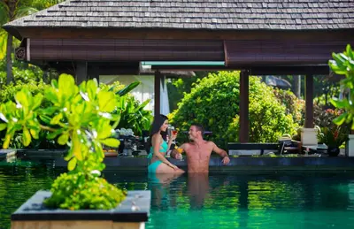 a man and a woman sitting in a swimming pool at The Seminyak Beach Resort & Spa in Seminyak