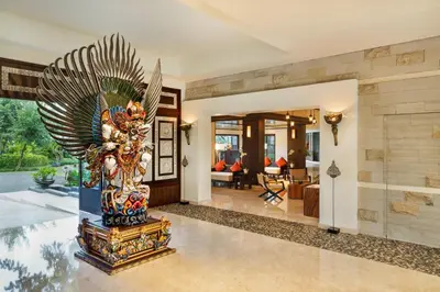 a lobby with a statue in the middle of a room at The Seminyak Beach Resort & Spa in Seminyak