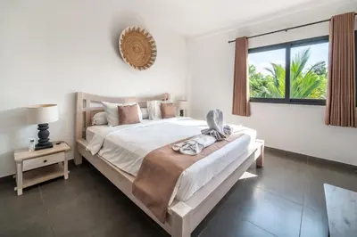 a bedroom with a large bed and a window at Villa Wiana by Villa Finder in Seminyak