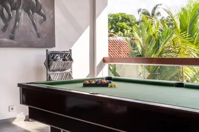 a billiard table in a living room with a pool table at Villa Wiana by Villa Finder in Seminyak