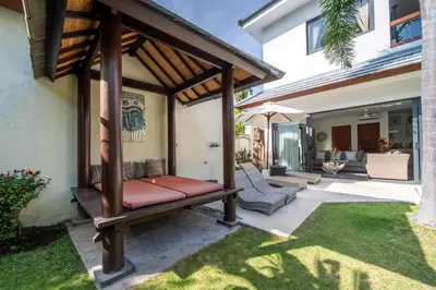 a patio with a bench in a house at Villa Wiana by Villa Finder in Seminyak