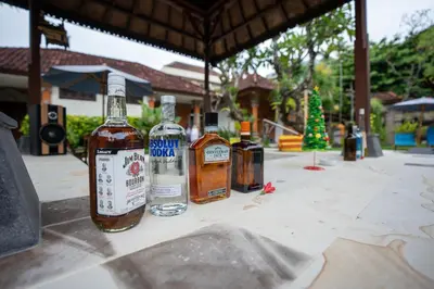 three bottles of whiskey sitting on a table at Hotel Sinar Bali Legian in Legian