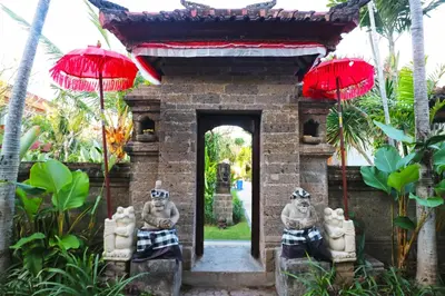 a gate to a temple with red umbrellas at Hotel Sinar Bali Legian in Legian